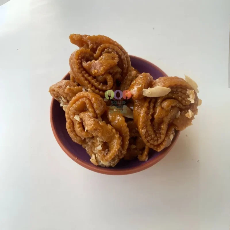 Authentic Moroccan chebakia honey cookies sprinkled generously with toasted sesame seeds on a traditional serving plate